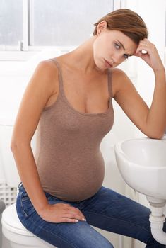 Some days are challenging...a pregnant woman experiencing discomfort in the bathroom at home