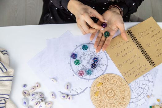 Woman numerologist astrologer counts numbers. Selective focus. People.