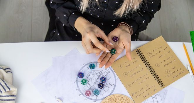 Woman numerologist astrologer counts numbers. Selective focus. People.