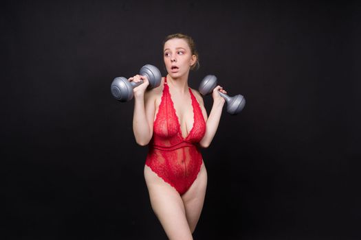 Strong sportswoman in boxing gloves prepared high kick. Isolated on a white, red, yellow background