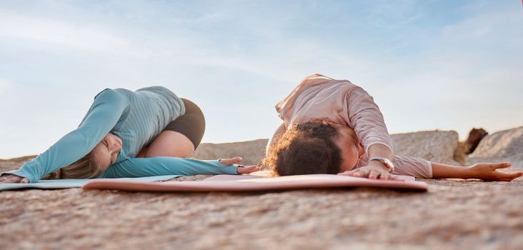 Yoga, women or stretching on beach mat in workout, training or bonding exercise twist for back pain. Child pose, relax or yogi friends in nature pilates or fitness flexibility for healthcare wellness.