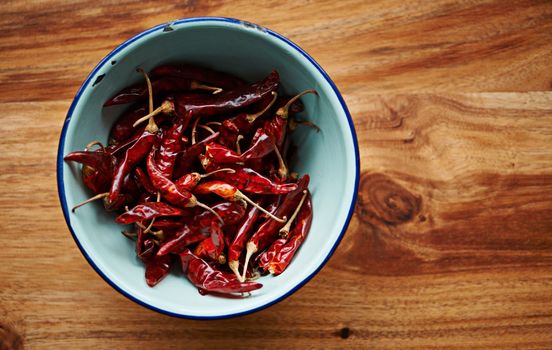 Intensely spicy. High angle shot of dried red chillies in a bowl on a kitchen counter