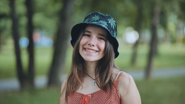 Portrait of a teenage girl in a panama hat in a park in the summer