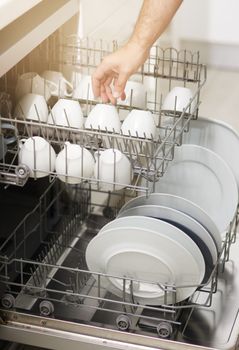 Dishwashing never has to be a chore again. a person loading a dishwasher at home