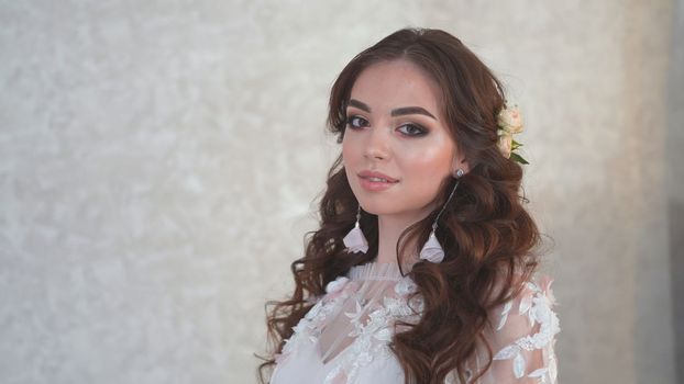 Girl model in a white dress shows beautiful makeup on her face