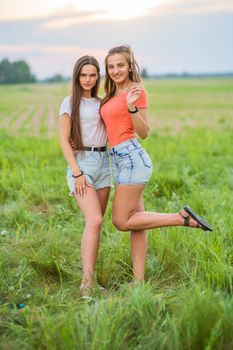 Photo session of two long-haired girlfriends in the field