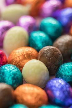 Big pile of colorful wrapped chocolate easter eggs, shiny festive Easter concept, Happy easter close-up candy sweets concept macro various colors