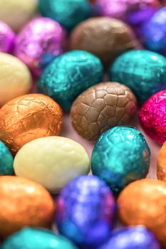 Big pile of colorful wrapped chocolate easter eggs, shiny festive Easter concept, Happy easter close-up candy sweets concept macro various colors