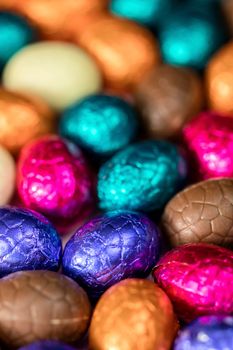 Big pile of colorful wrapped chocolate easter eggs, shiny festive Easter concept, Happy easter close-up candy sweets concept macro various colors
