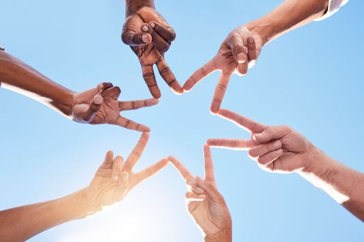Star, hands and team, solidarity and peace with diversity and community collaboration with blue sky and sun. Team building, together and group with support and trust, hand gesture and sign outdoor