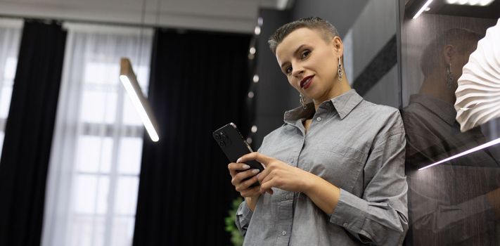 successful woman head standing with mobile phone in modern office.