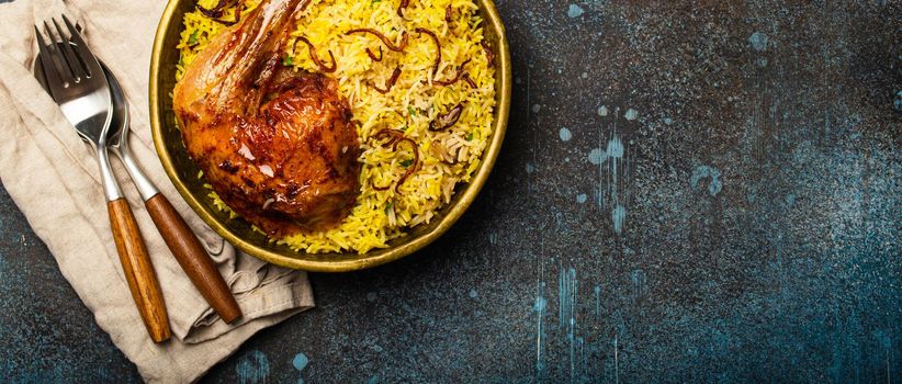 Delicious Indian dish Biryani chicken with basmati rice in metal brass old bowl on table rustic stone background. Traditional non-vegetarian food of India, top view with space for text