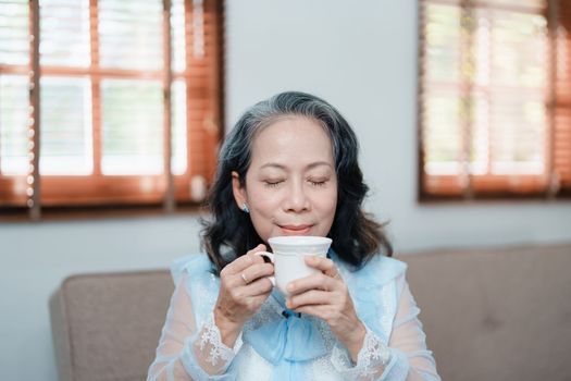 Portrait of an elderly Asian woman drinking tea for health