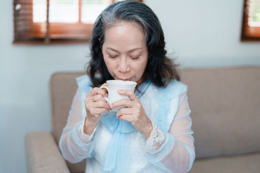 Portrait of an elderly Asian woman drinking tea for health