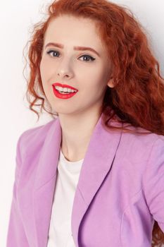 Closeup portrait of satisfied delighted red haired woman looking at camera pleasant smile, expressing positive emotions, wearing Indoor studio shot isolated on gray background.
