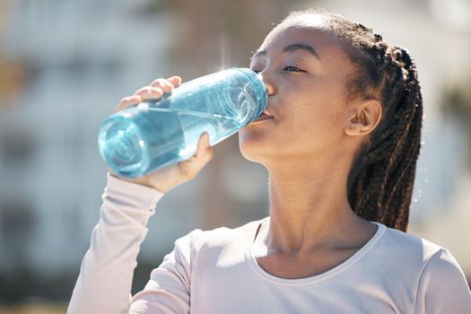 Drinking water, fitness and black woman in urban city with workout challenge for health, wellness and nutrition. Young sports, athlete or runner woman with water bottle for exercise, training outdoor.