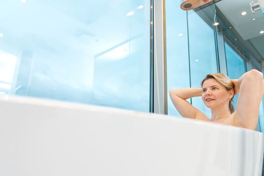 woman in freestanding white bath. Modern bathroom interior design. Beauty, healthy lifestyle concept. panoramic bathroom interior
