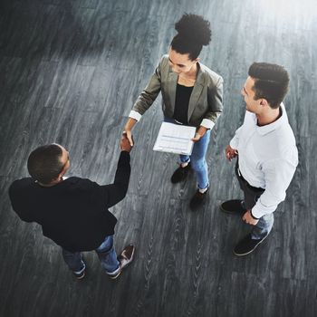 Network to let more people know about your business. High angle shot of two businesspeople shaking hands in an office