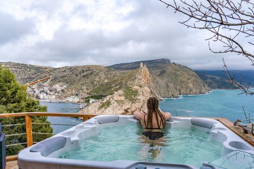 Spa woman sea view. Find time for yourself. A woman in a black swimsuit is resting admiring the beautiful view.