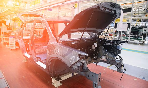 Photo of automobile production line. Modern car assembly plant. Modern and high-tech automotive industry. Conveyor of auto bodies