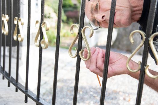 close up a man paints a fence in gold paint, metal restoration,seasonal work to restore the home and garden in the spring, Do it yourself , High quality photo