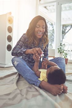 You want your dummy. Full length shot of a young mother and her little baby girl at home