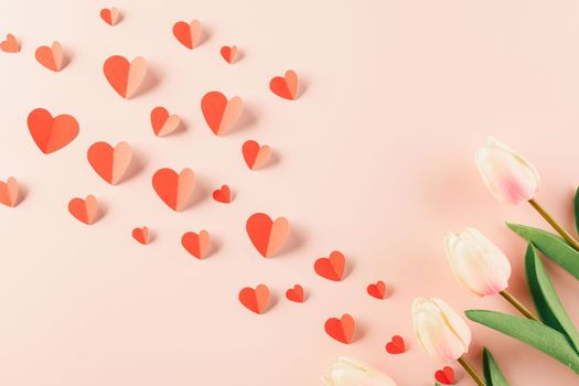 Happy Valentines Day background. Top view flat lay of red paper hearts shape and pink tulips flower on pink background with copy space, Valentine day concept, Banner of holiday
