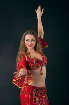 young woman dance and smile in red arabian costume