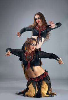 Two woman dance in ritual warrior cosutme