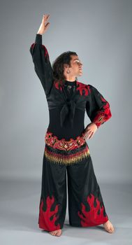 Man dance in traditional arabian costume on gray