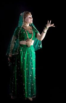 young girl in green indian costume look at light
