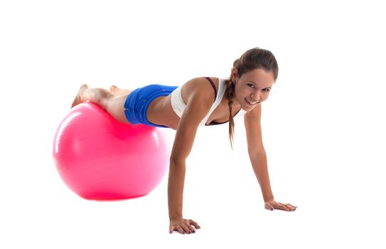 young woman posing in training on fitness ball isolated