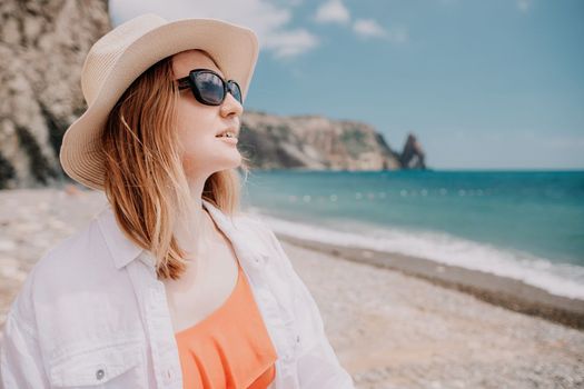 Young woman in red bikini on Beach. Blonde in sunglasses on pebble beach enjoying sun. Happy lady in one piece red swimsuit relaxing and sunbathing by turquoise sea ocean on hot summer day. Close up,