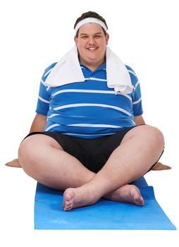 Waiting to get my burn on. A studio shot of a young man sitting on an exercising mat