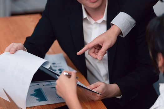 Harmony in office concept as business people analyzing dashboard paper together in workplace. Young colleagues give ideas at manager desk for discussion or strategy planning about project.