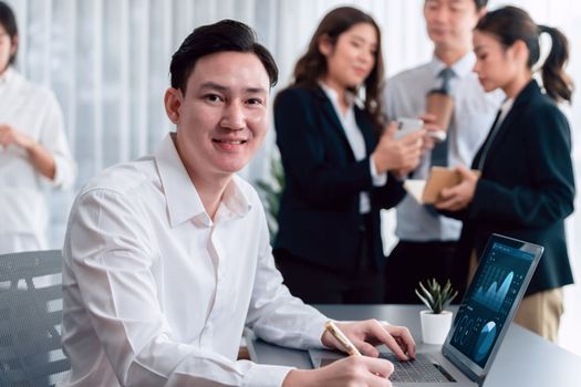 Portrait of focus young successful confident male manager, executive wearing business wear in harmony office arm crossed with blurred meeting background of colleagues, office worker.