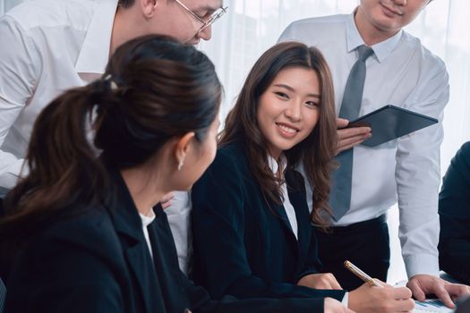 Harmony in office concept as business people analyzing dashboard paper together in workplace. Young colleagues give ideas at manager desk for discussion or strategy planning about project.