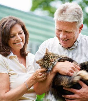 Hes like a member of the family. a senior couple with their cat outdoors