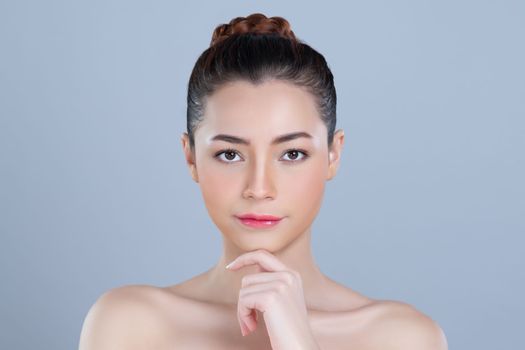 Glamorous woman portrait with perfect smooth pure clean skin with soft cosmetic makeup in isolated background. Beauty hand gesture with expressive facial expression for skincare product or spa ad.