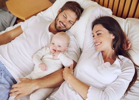 The perfect family. High angle shot of a young couple and their baby daughter in the bedroom