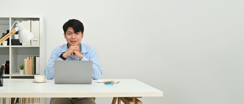 Banner panorama of smiling businessman using laptop over white background. Empty copy space for your text.