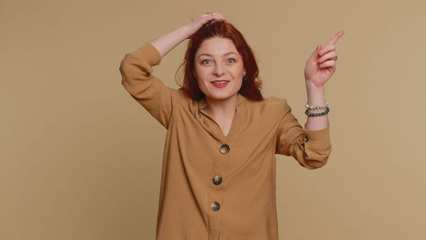 Eureka. Inspired redhead woman pointing finger up with open mouth, having good idea, plan, startup, showing inspiration motivation gesture, problem solution. Young girl isolated on beige background