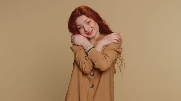 Come to me, I want to embrace you. Happy smiling redhead woman spread hands and give hug to you. Pleasant expression, love feelings. Young ginger girl isolated alone on beige studio background