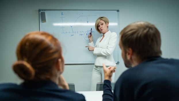 Caucasian woman blonde leads a presentation for colleagues