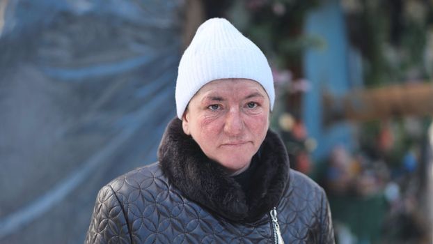 Portrait of a homeless woman in winter in the woods