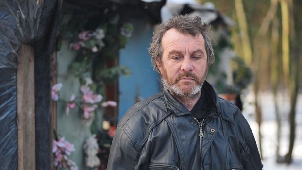 A homeless man poses for the camera in winter in the woods