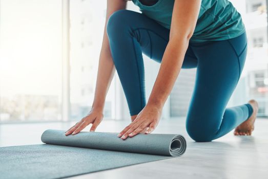 Yoga, studio and exercise mat with the hands of a black woman at the start of a zen workout. Fitness, training and roll with a female yogi indoor for mental health, balance or spiritual wellness.