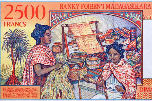 Woman weaving from Malagasy money - Ariary