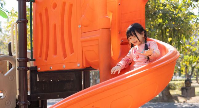 Happy children girl playing and having fun at the playground.