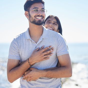 Hug, happy young couple at beach with travel and care on summer holiday by ocean, commitment and support outdoor. Partner, embrace and relationship with romantic date, man and woman on vacation.